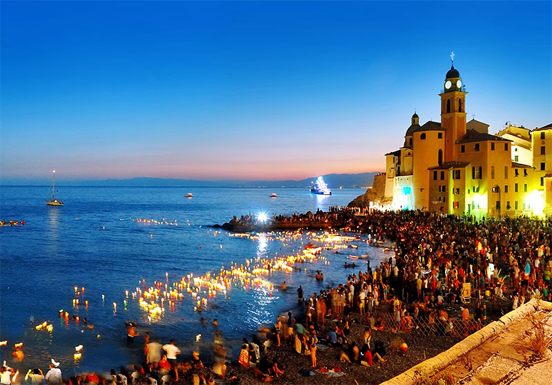 People with candles on the beach at night in Camogli