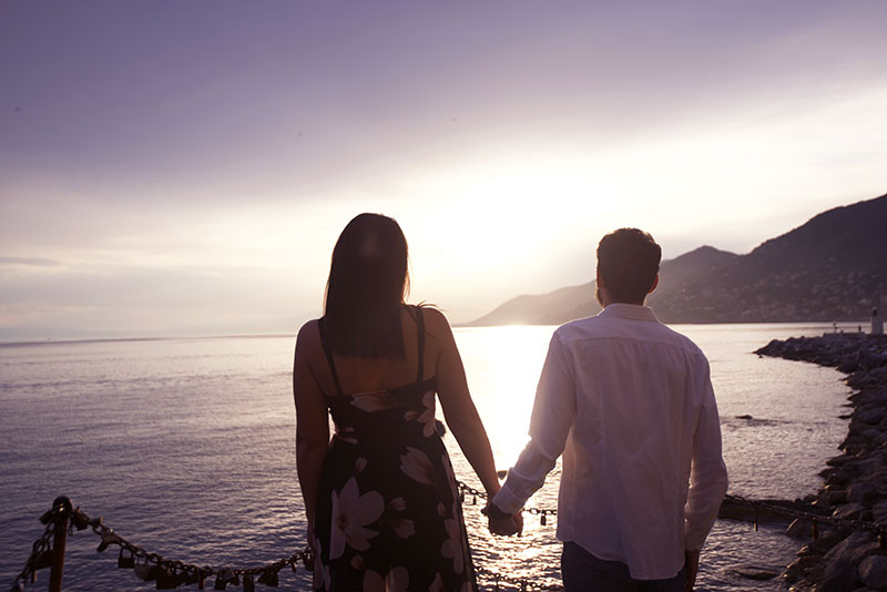 Couple watching the panorama on the coast of Camogli at sunset