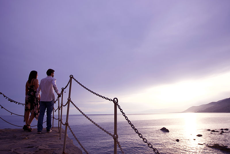 Coppia che guarda il panorama sulla costa di Camogli al tramonto