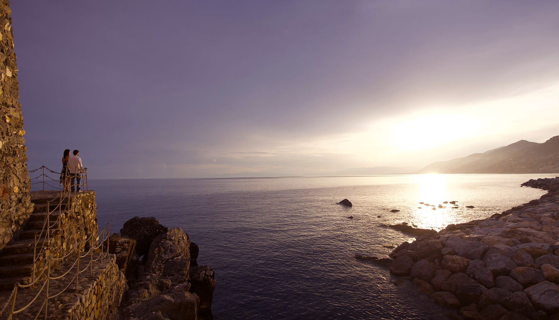 Paar beobachtet das Panorama an der Küste von Camogli bei Sonnenuntergang